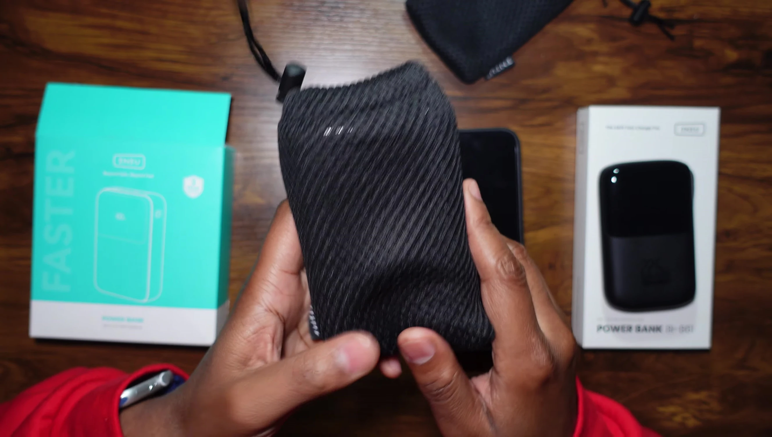 Comparison of the larger 25,000mAh INIU power bank with the reviewer's hand to showcase its size.