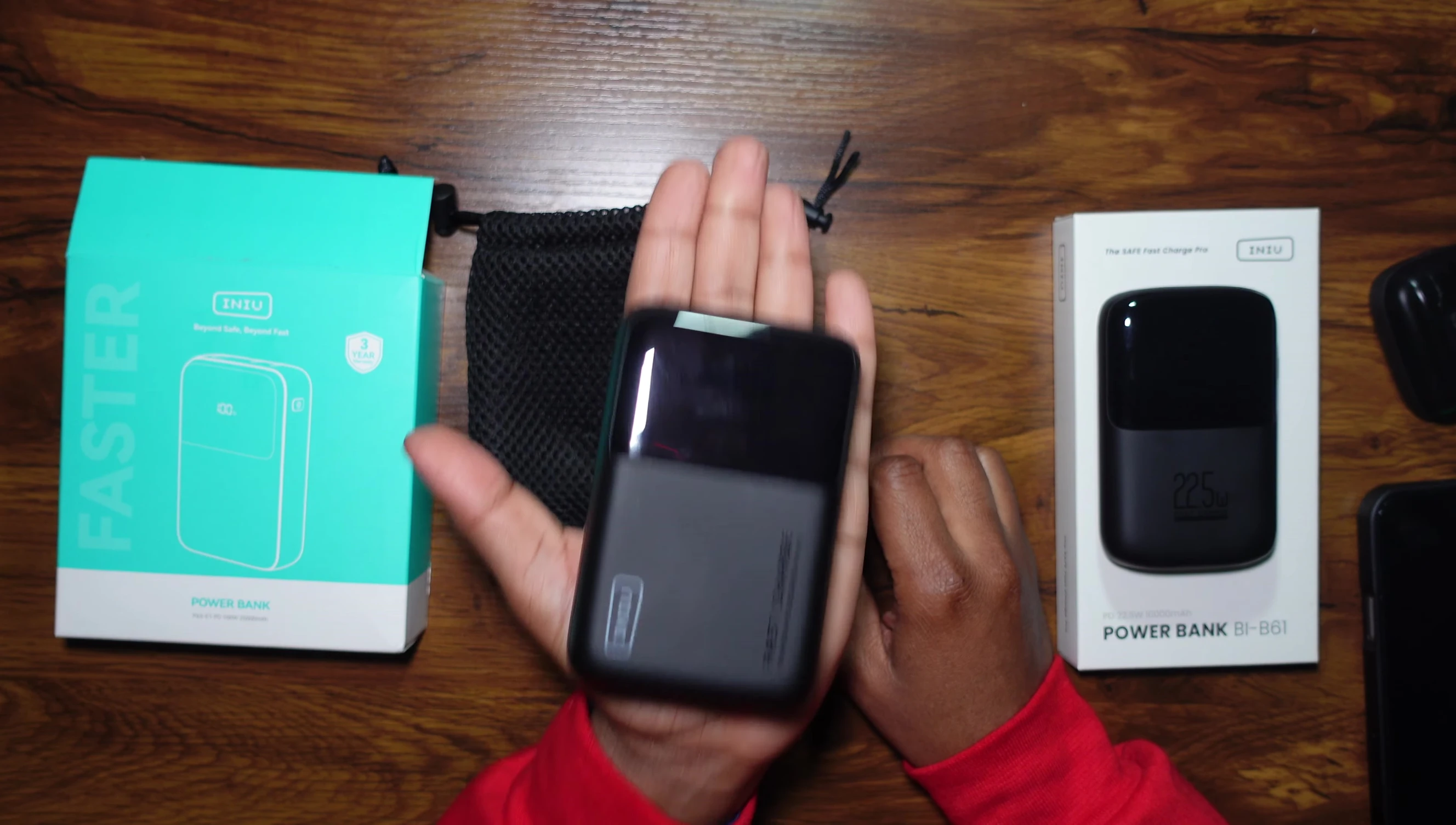 A comparison shot showing the size difference between the two power banks and the reviewer's hand.