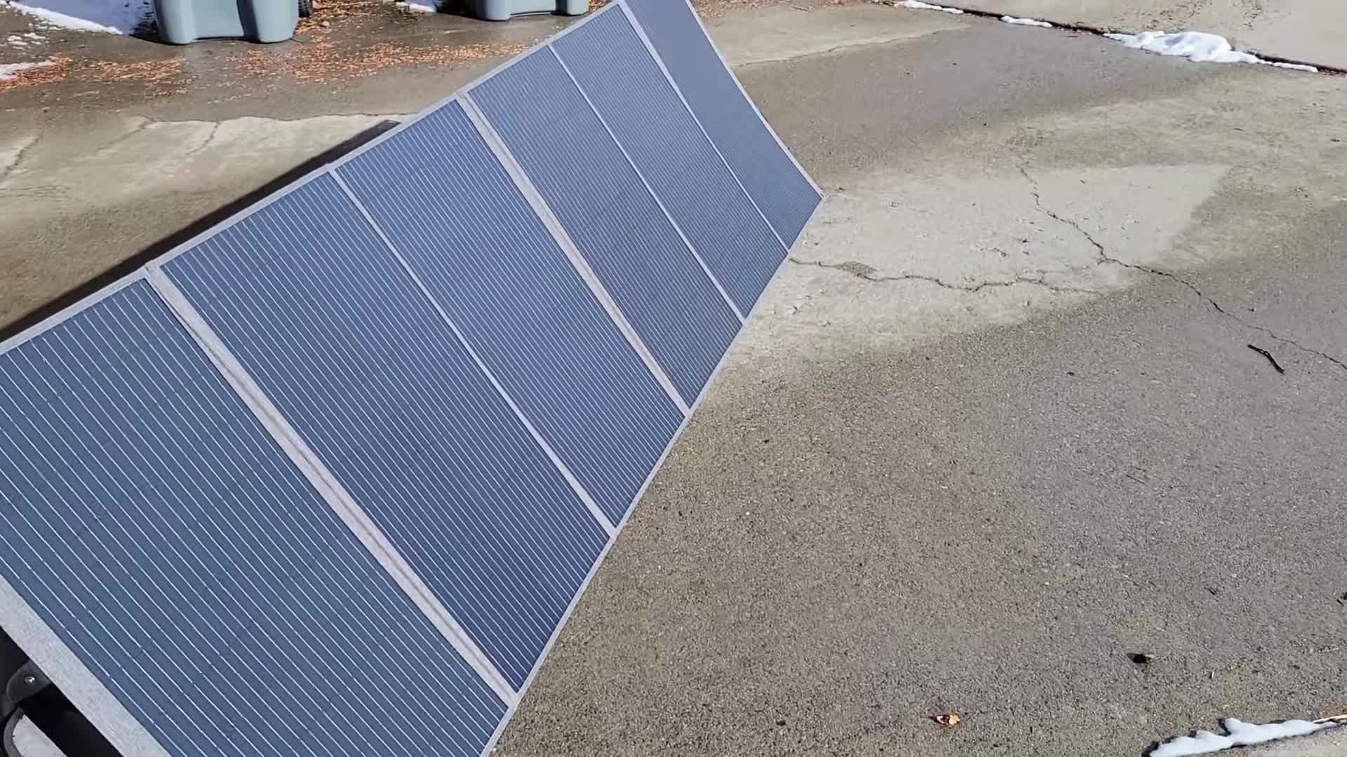 The reviewer holding the folded solar panel, highlighting its compact nature.