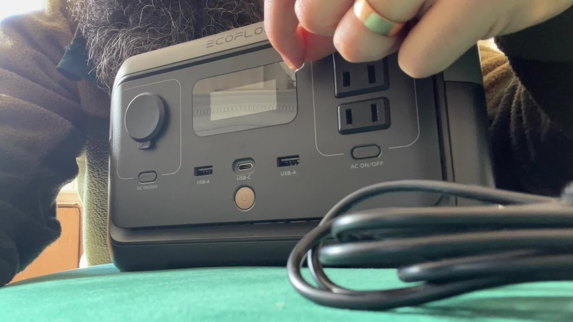 Close-up of the EcoFlow River 2 with the protective screen cover being removed.