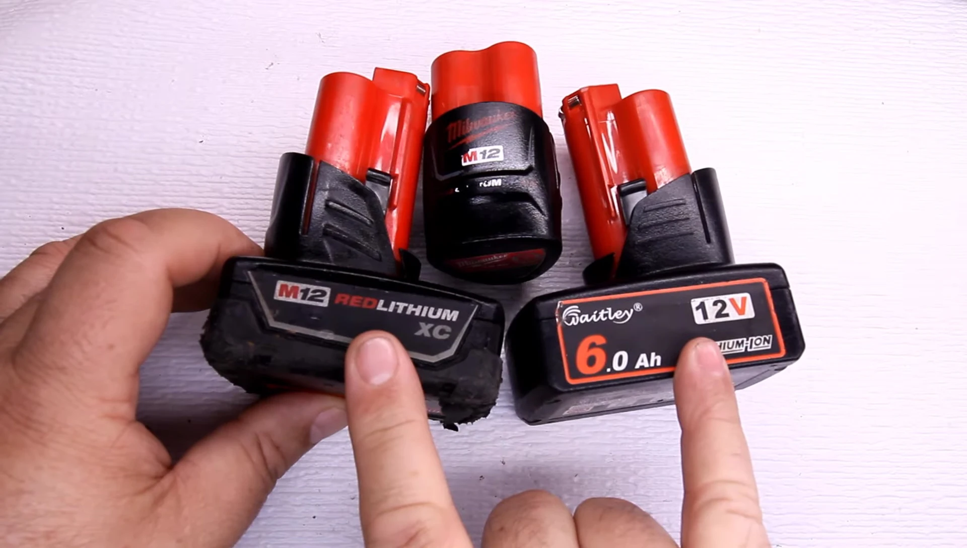 Close-up of the three batteries: Milwaukee 3.0Ah, Milwaukee 1.5Ah, and the off-brand 6.0Ah battery.