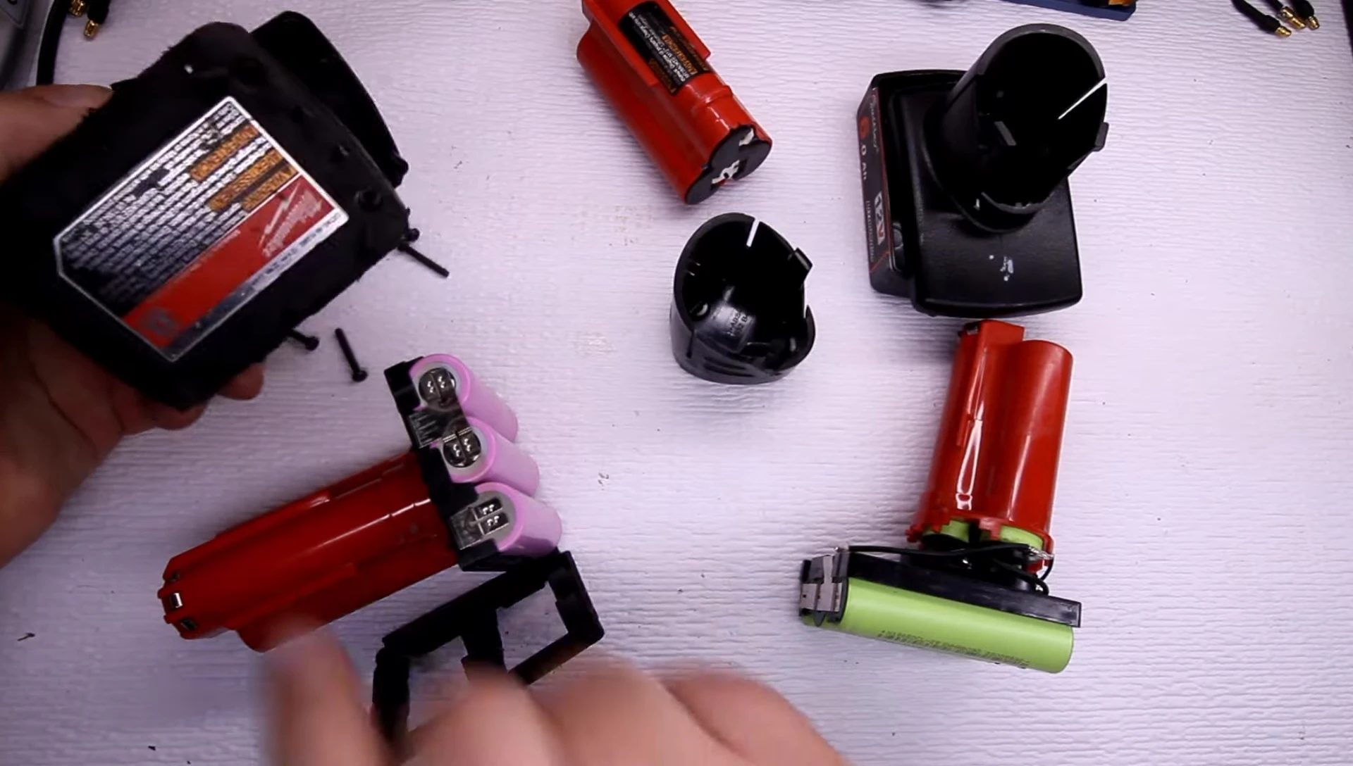 Presenter showing the process of taking the Milwaukee battery apart.
