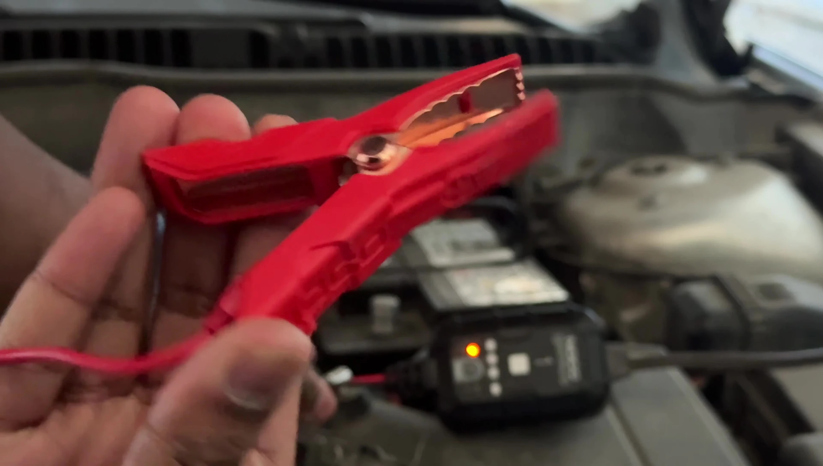 Connecting the alligator clips to the car battery terminals.