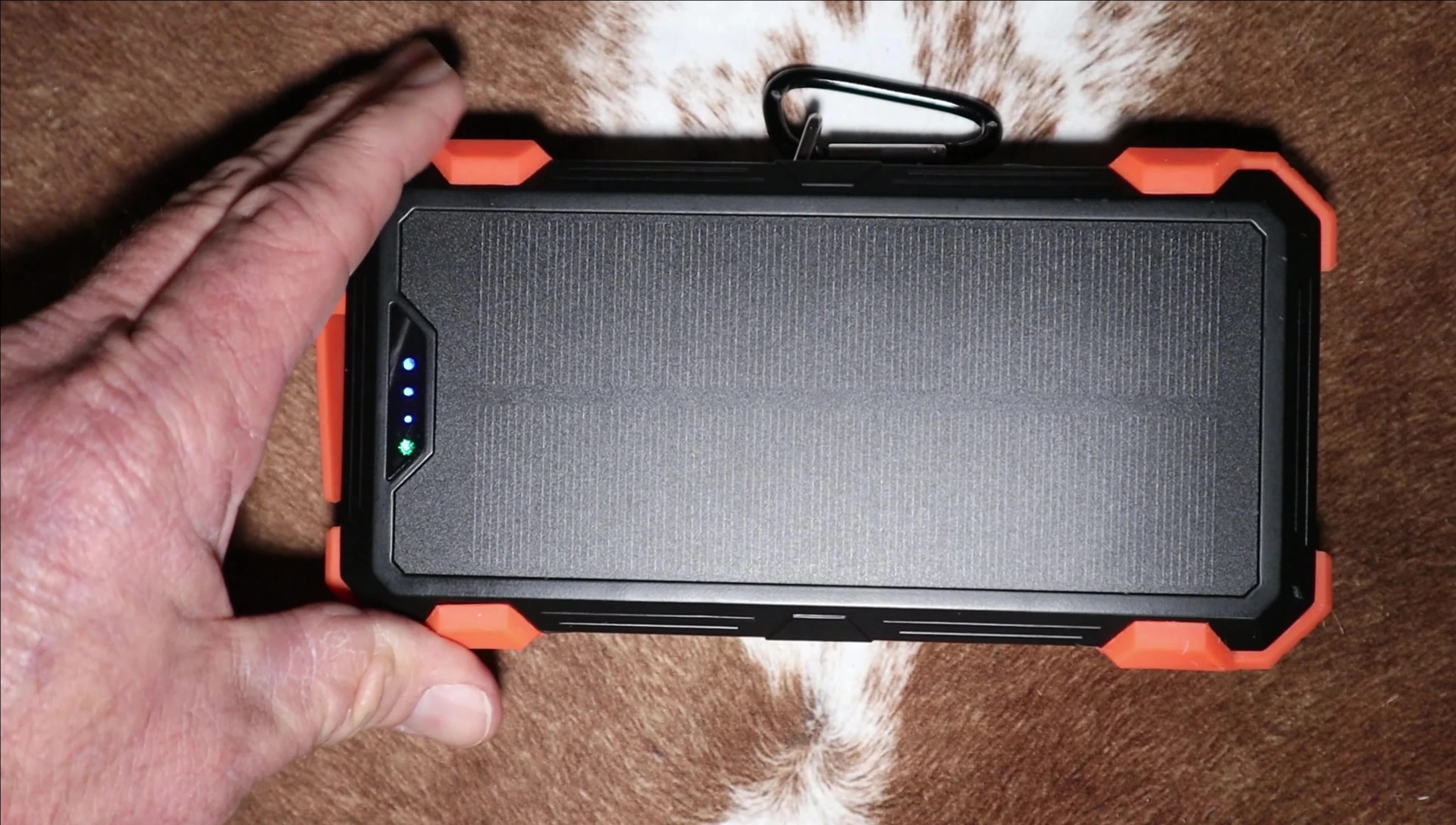 Close-up of the GOODaaa solar power bank showing its ports and carabiner