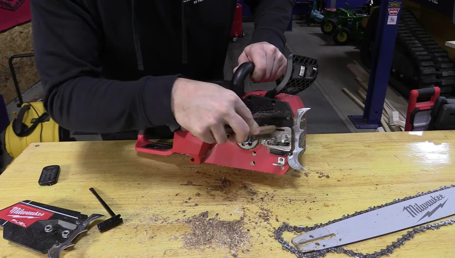 The reviewer holding and demonstrating the weight of the chainsaw.