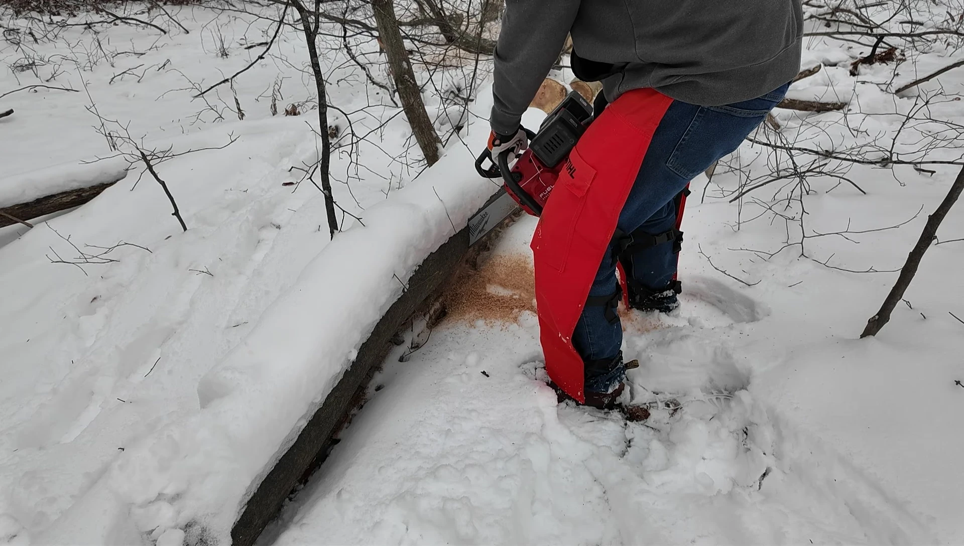 Close-up shot of the chainsaw's trigger and safety features.