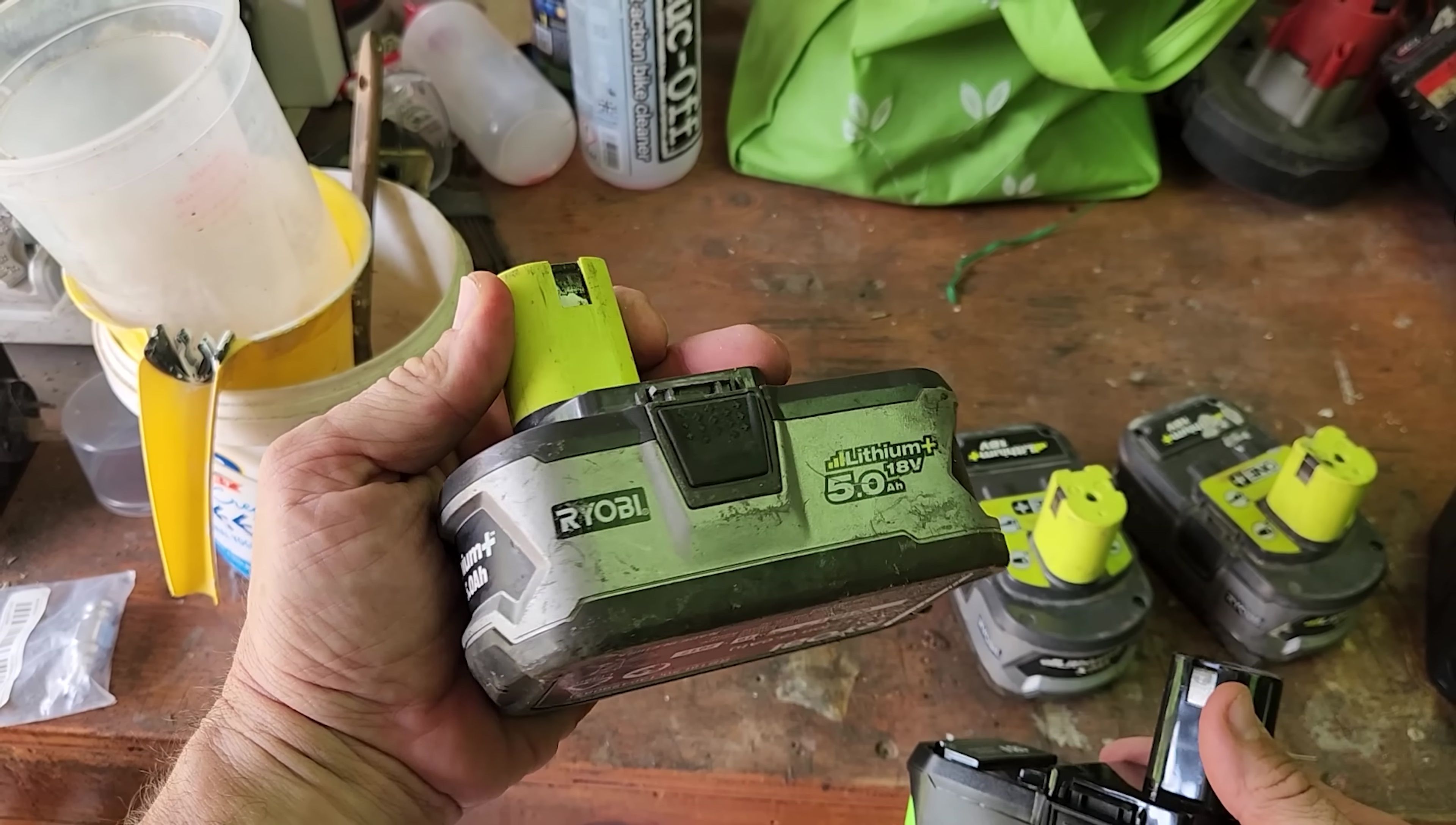Comparison shot showing genuine Ryobi and third-party batteries side-by-side.