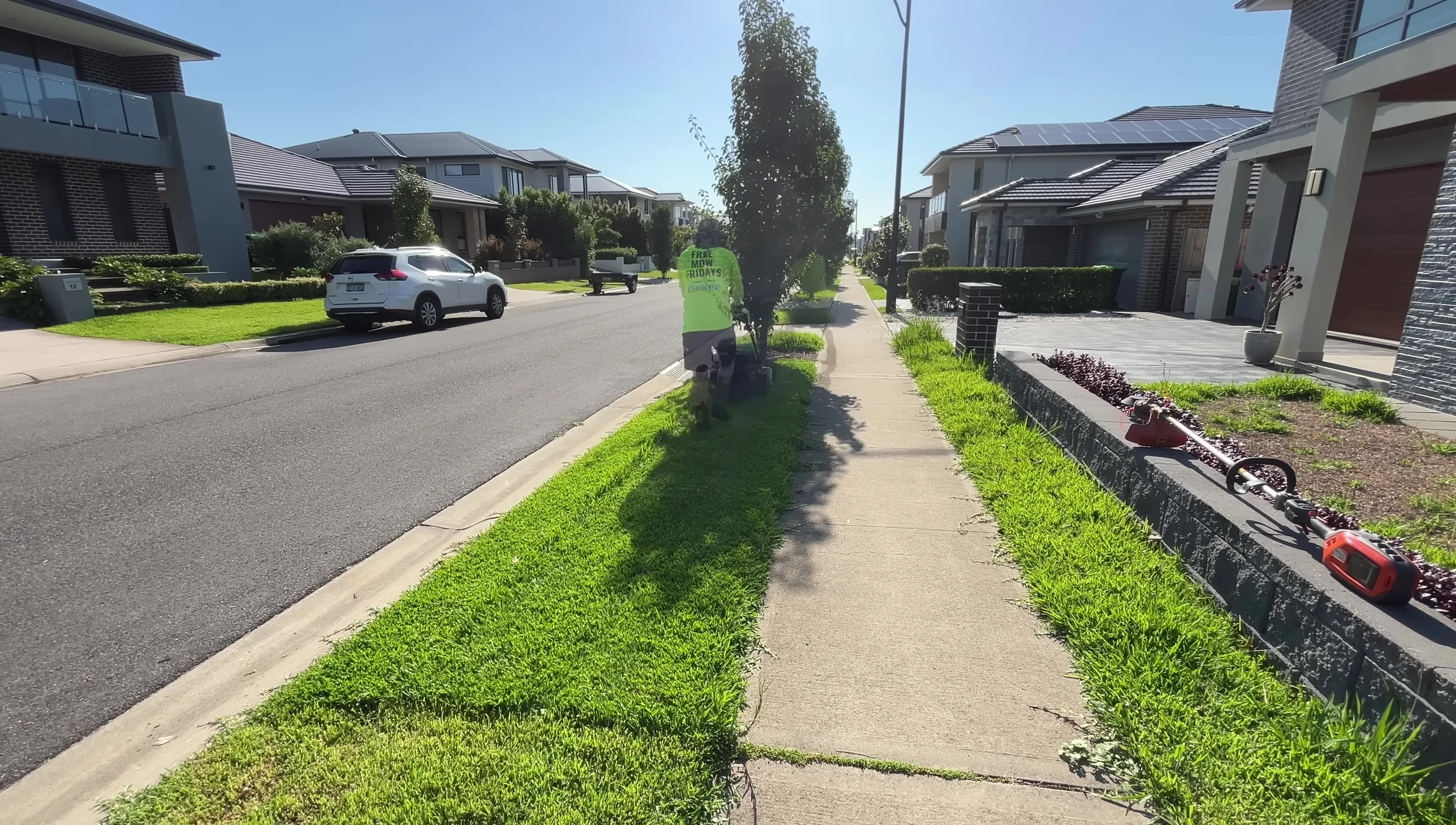The trimmer tackling thicker, overgrown grass.