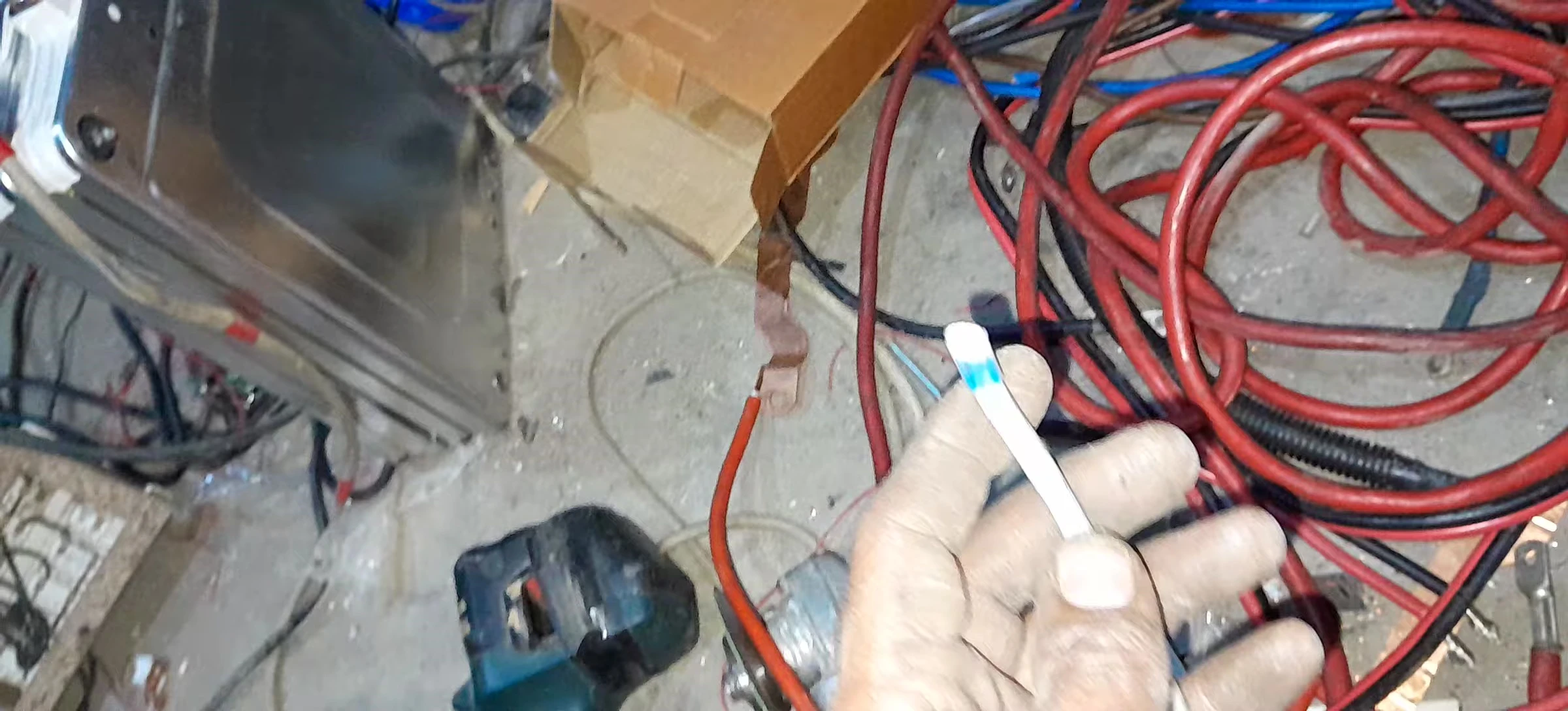 The builder showcasing the heavy-duty wire used in the battery construction.