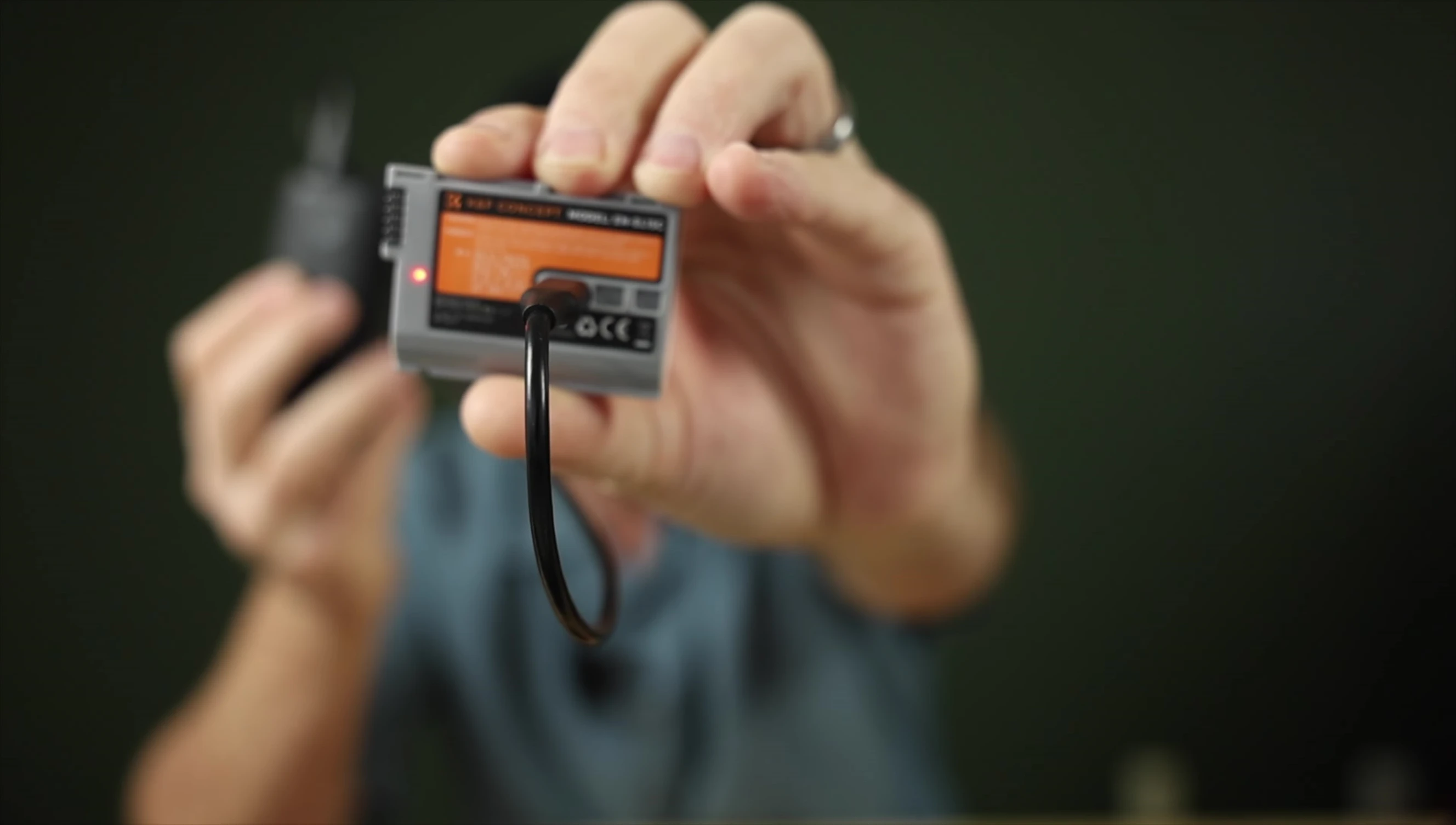 The reviewer's setup using a power bank to charge the K&F battery.