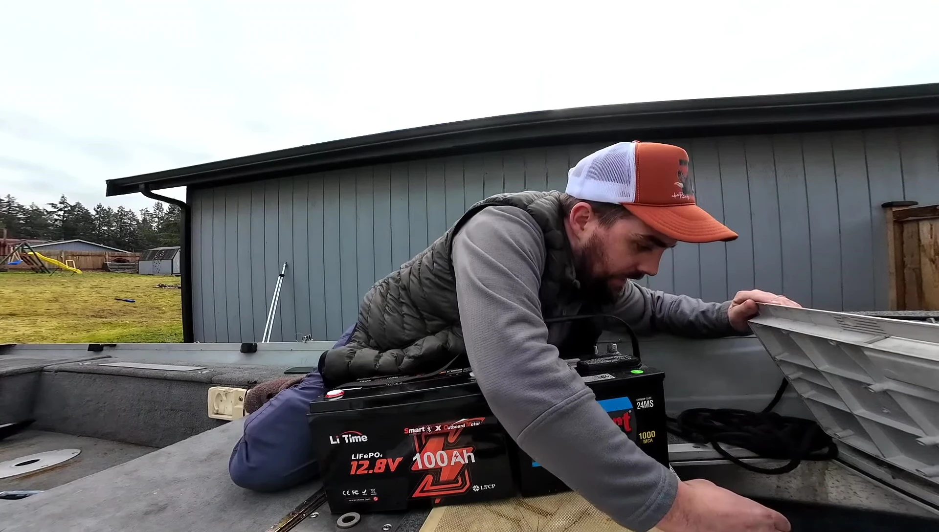 Installing the LiTime lithium battery into the boat's battery compartment.
