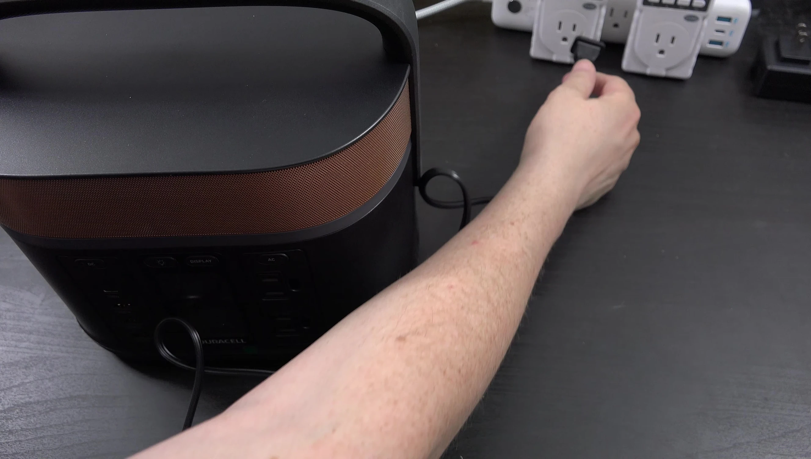The Duracell G350 plugged into a wall outlet, with a wattmeter monitoring its power draw.