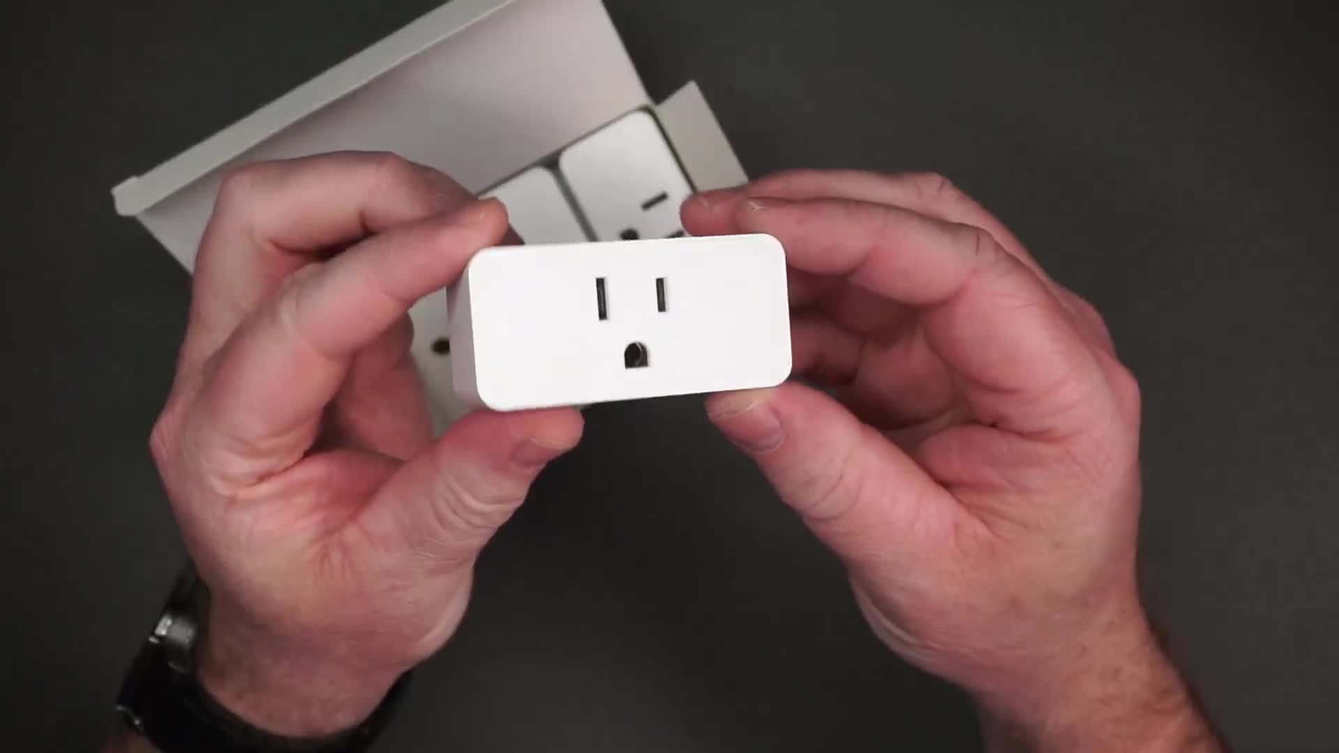 Close-up of a smart plug showing the on/off button and the outlet.