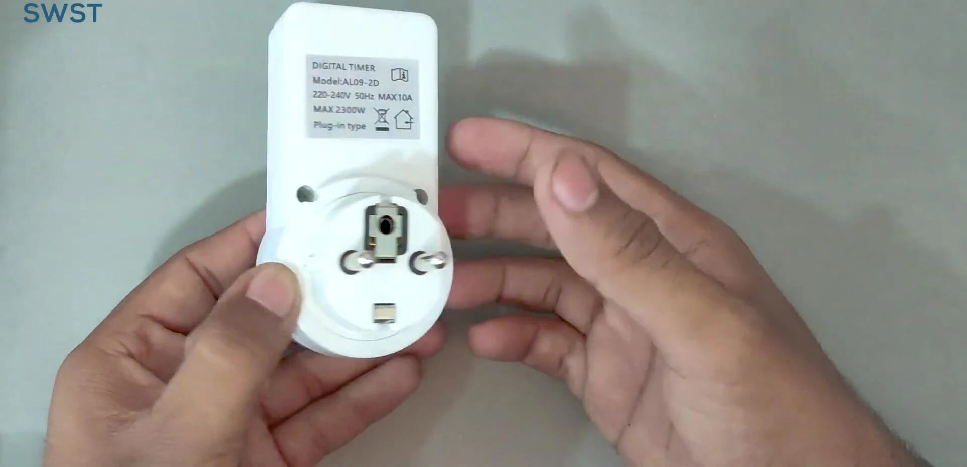 The timer switch being plugged into an electrical socket.