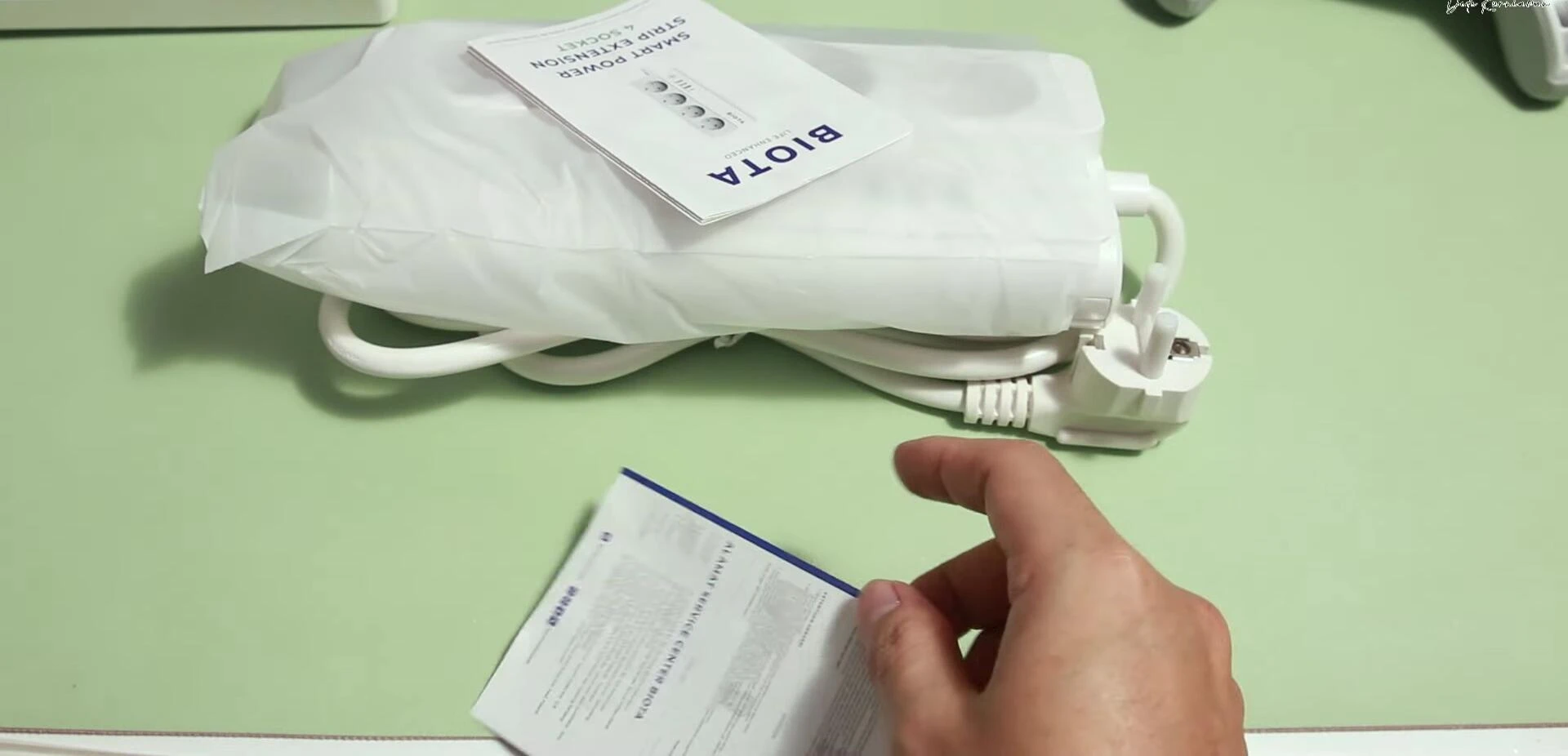 Unboxing the Biota Smart Power Strip, showing the manual and warranty card.