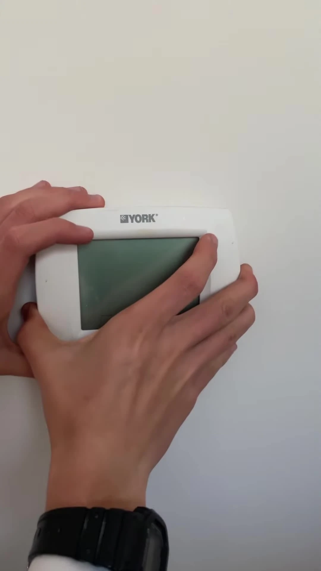 Removing the old thermostat from the wall.