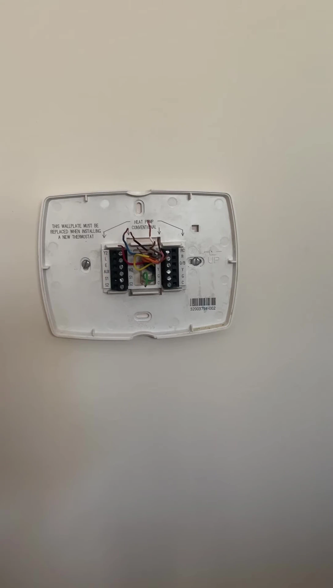 Removing the old thermostat from the wall.