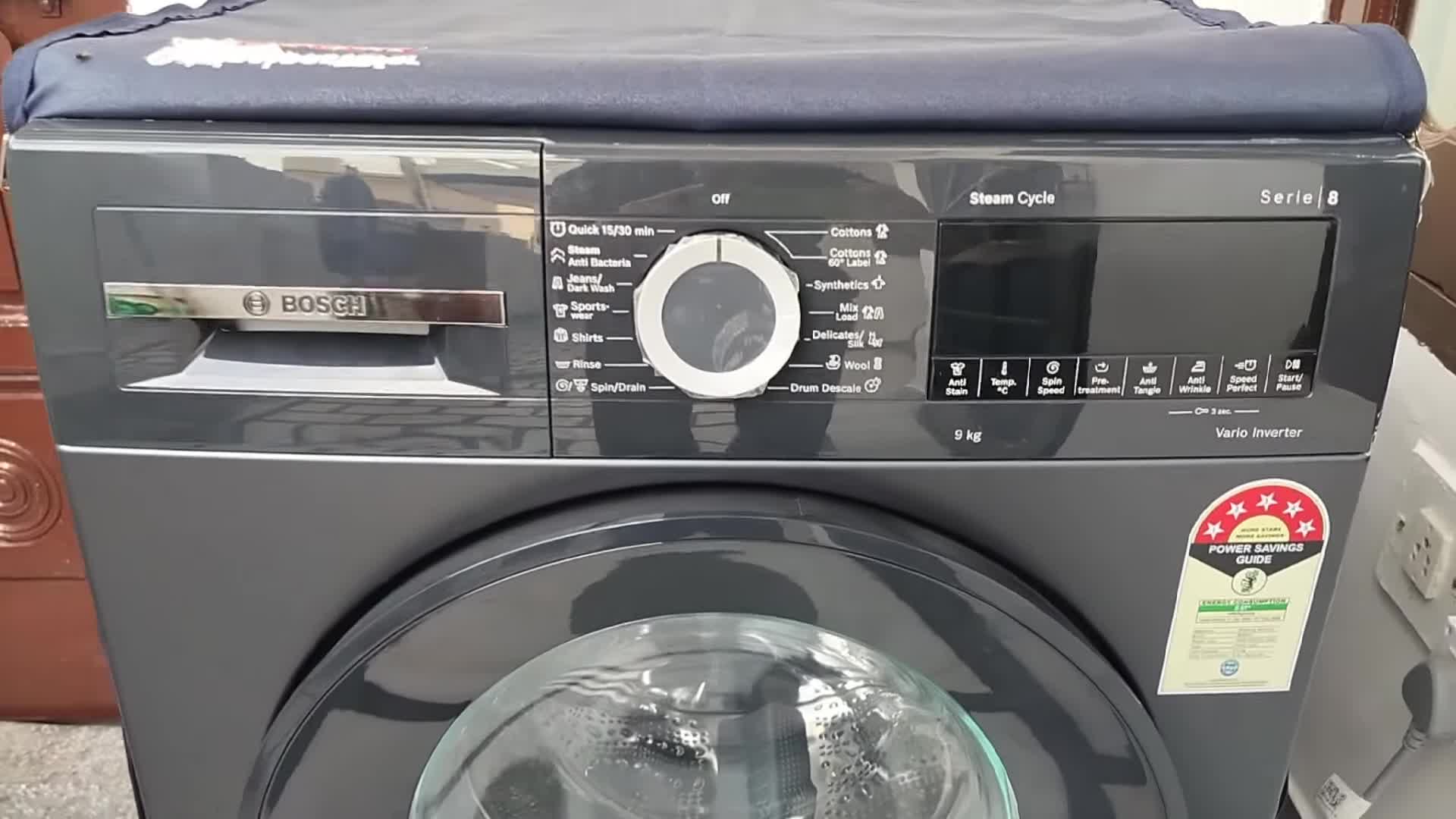 Close-up shot of the Bosch Series 8 washing machine, highlighting its black and grey color scheme.