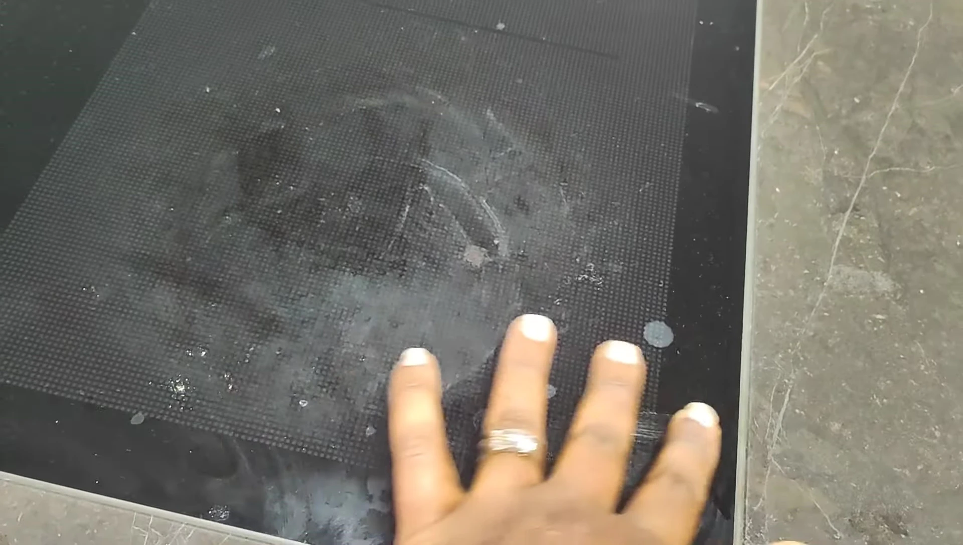 Close-up of the cooktop being cleaned with a sponge