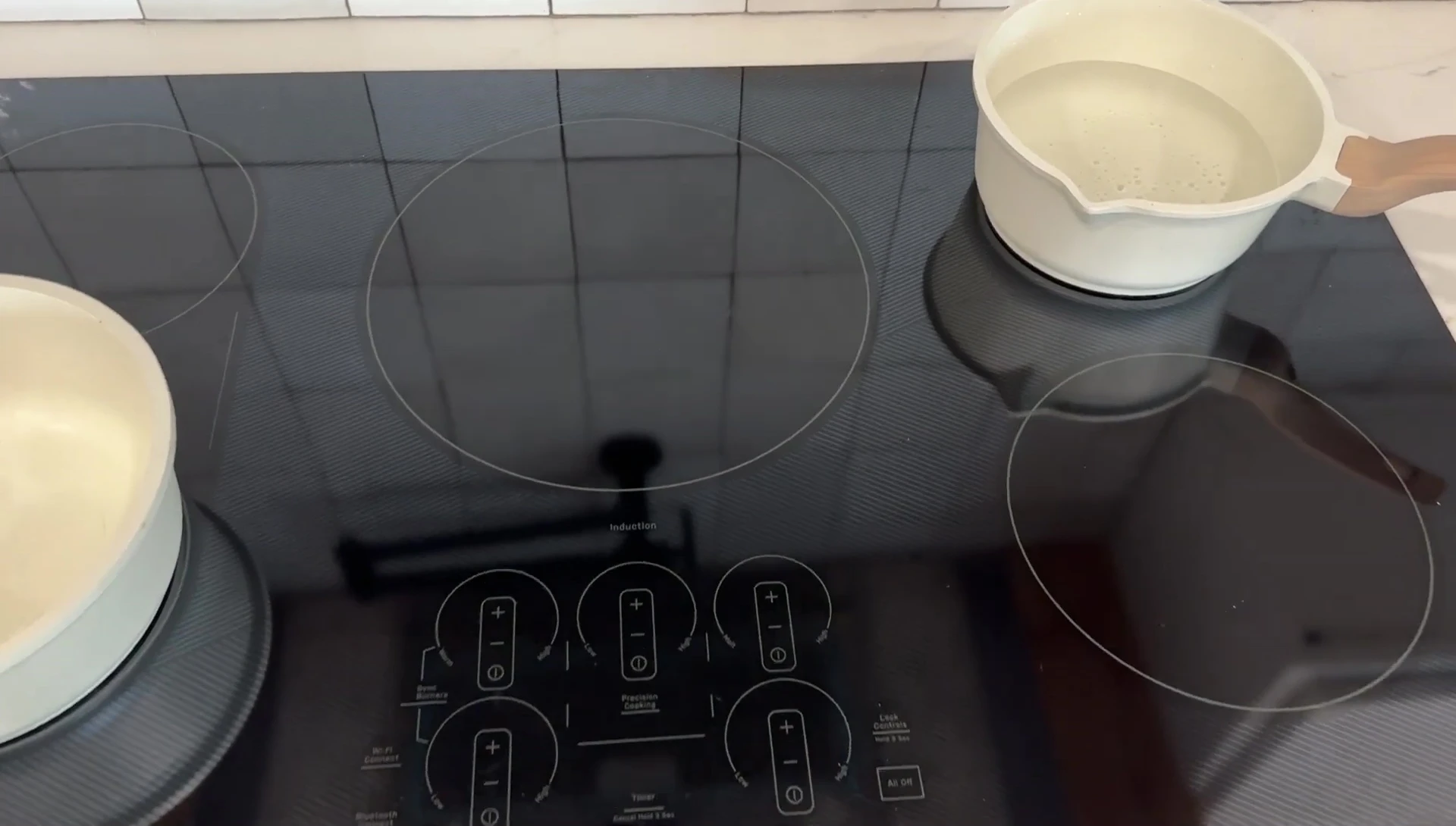 Close-up shot of the pot of water beginning to heat on the induction cooktop.