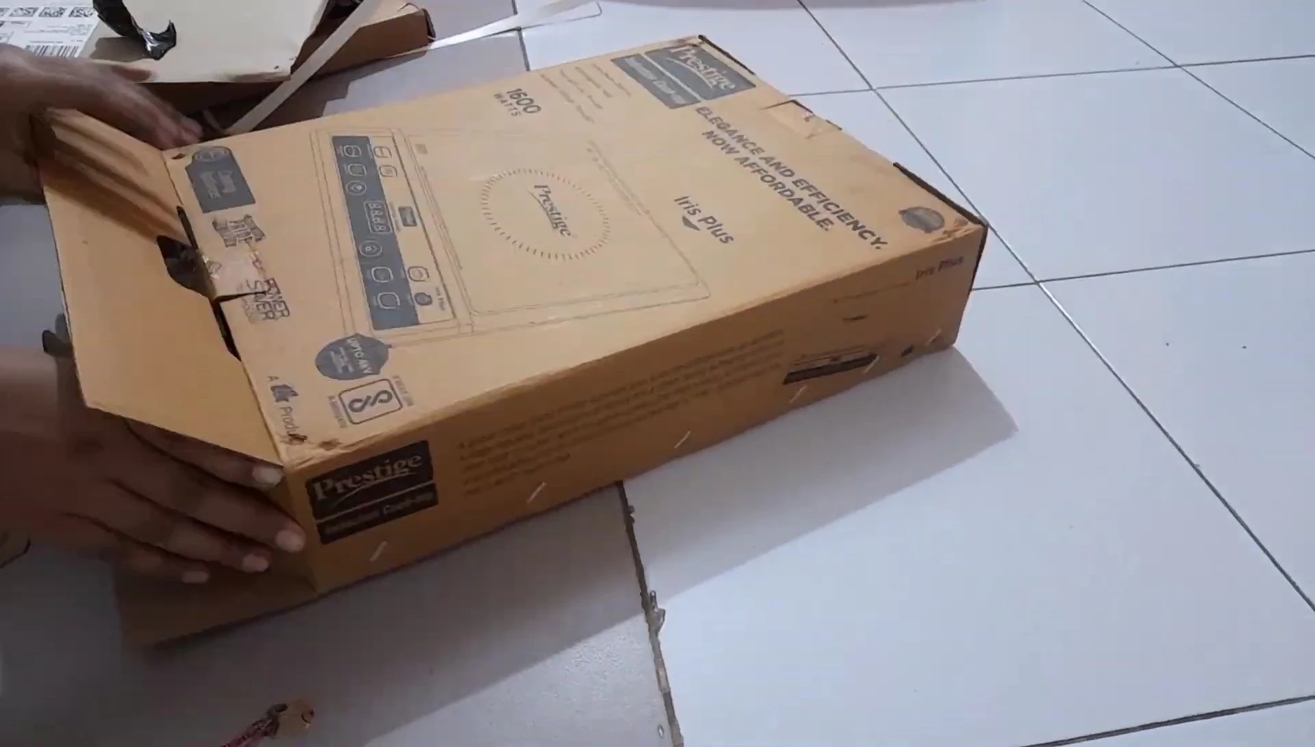 The reviewer struggling to open the cooktop box.