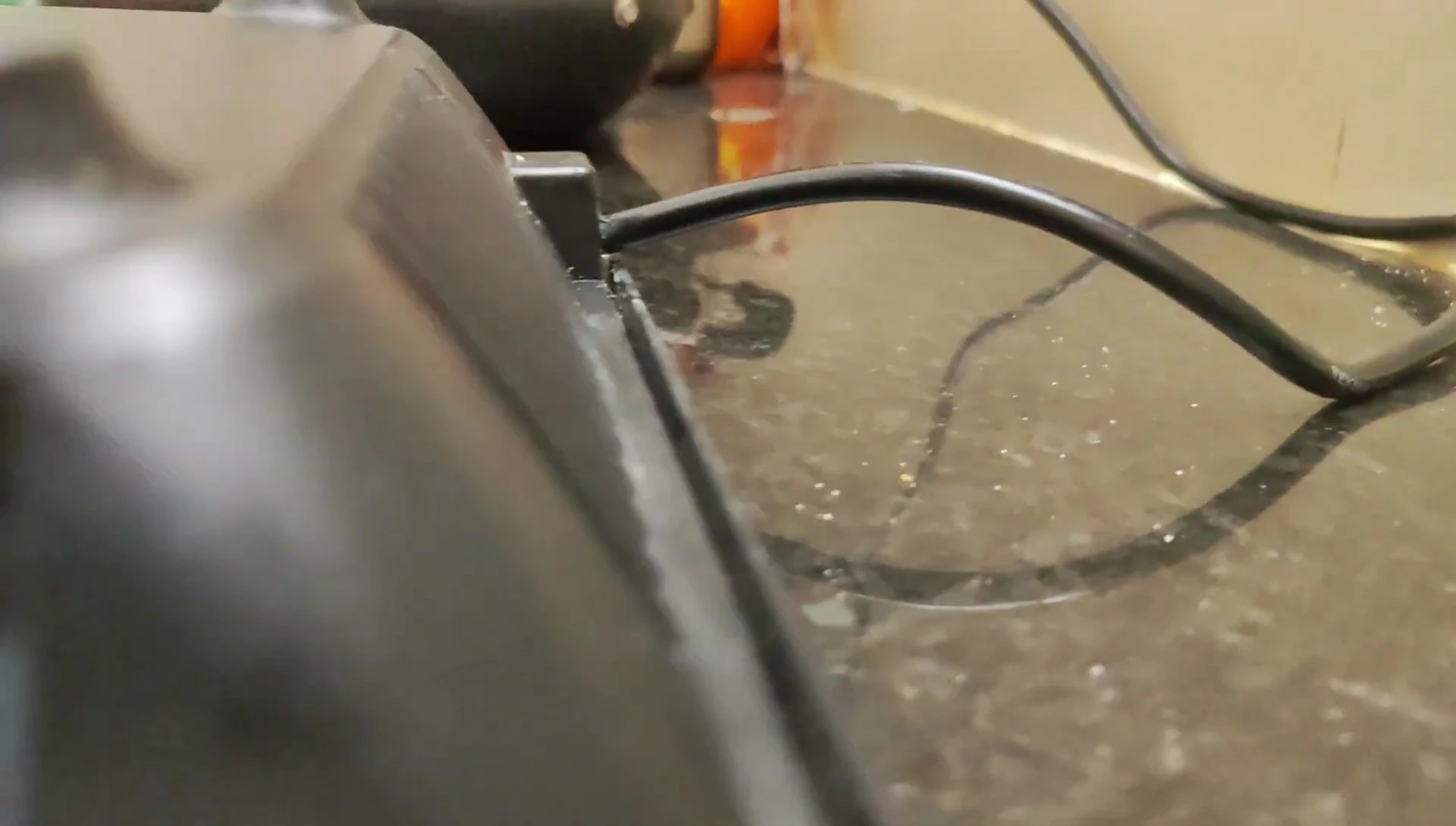 Close-up focusing on the cooktop's minimalist and stylish black glass surface.