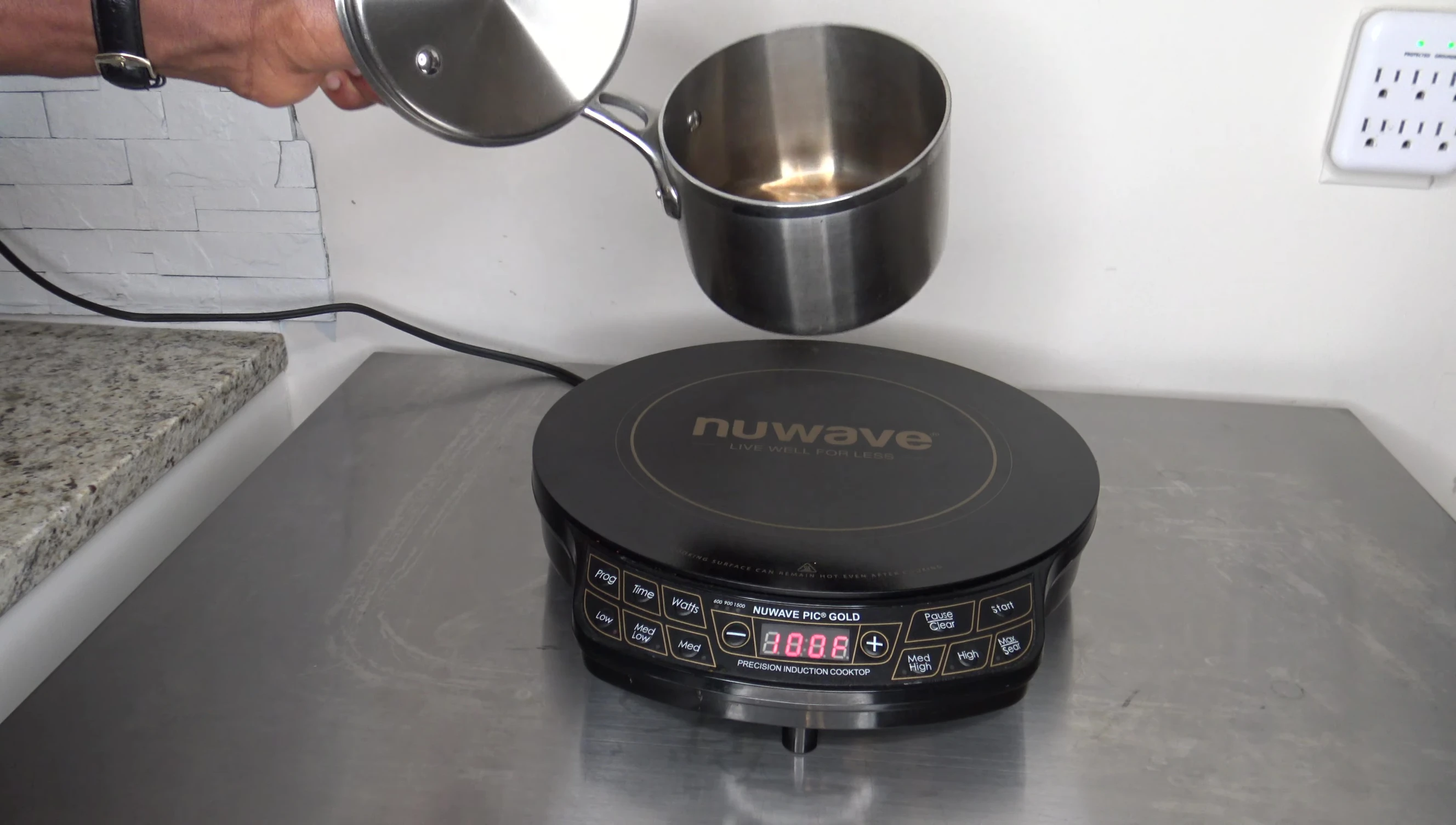 A cup of water on the cooktop, ready for the boiling test