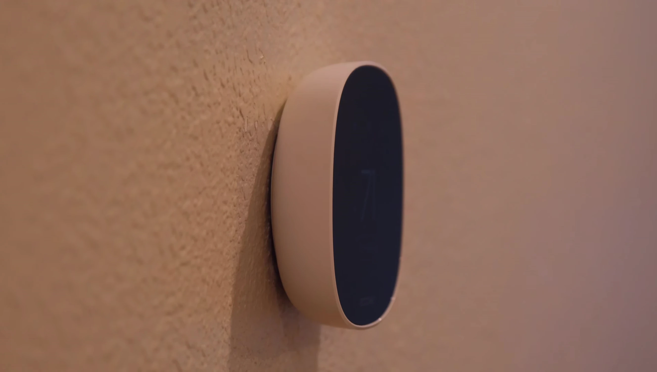 Close-up of the Ecobee Smart Thermostat Essential showing its white plastic body and black front panel.