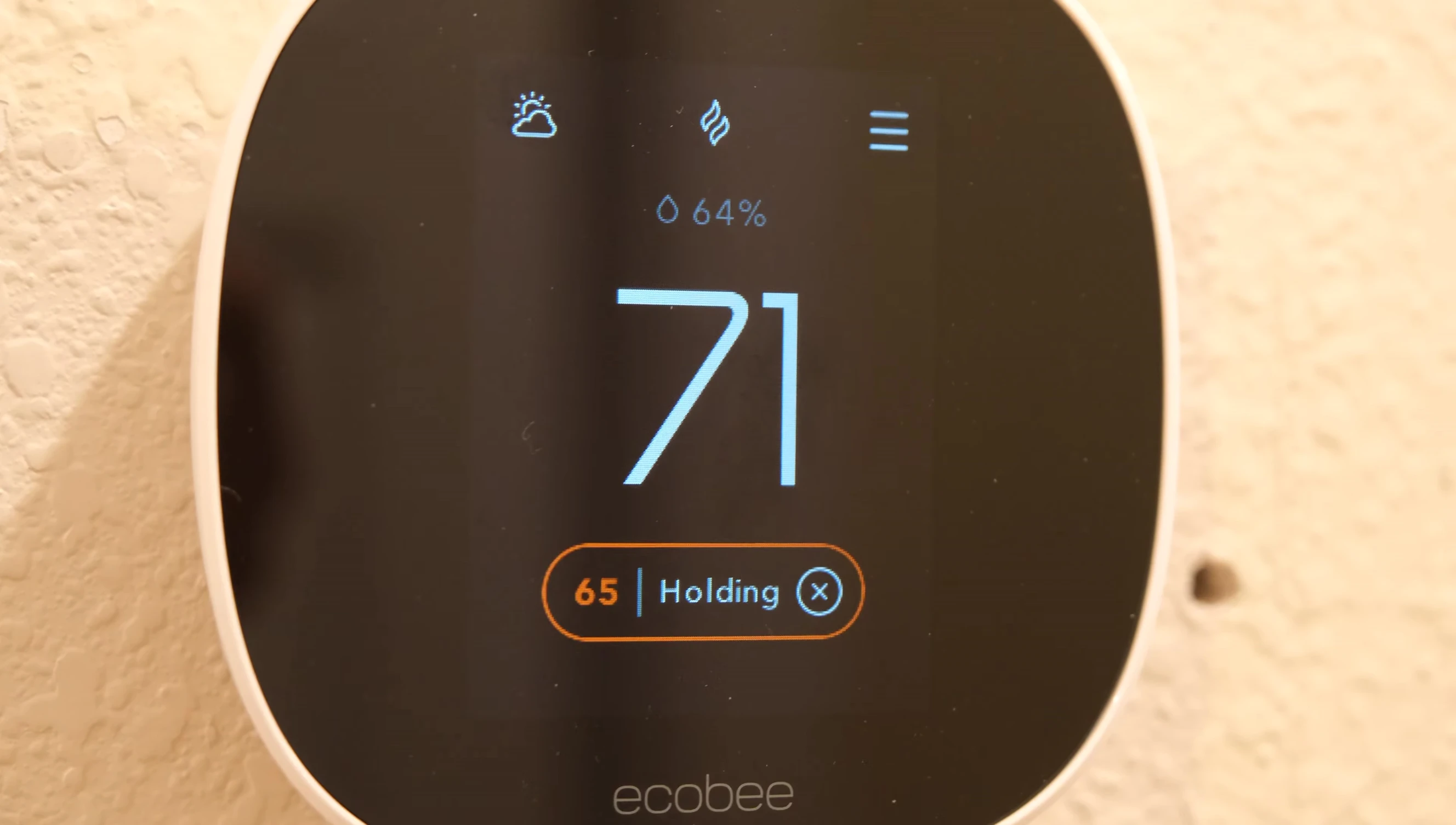 A shot showing the thermostat being installed on a wall.