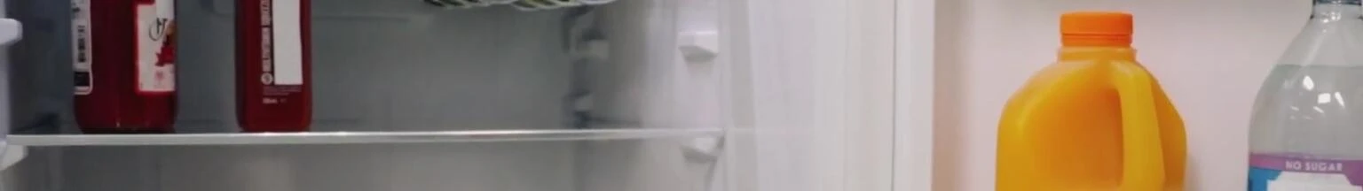 The bottom door shelf with milk and beverage bottles.