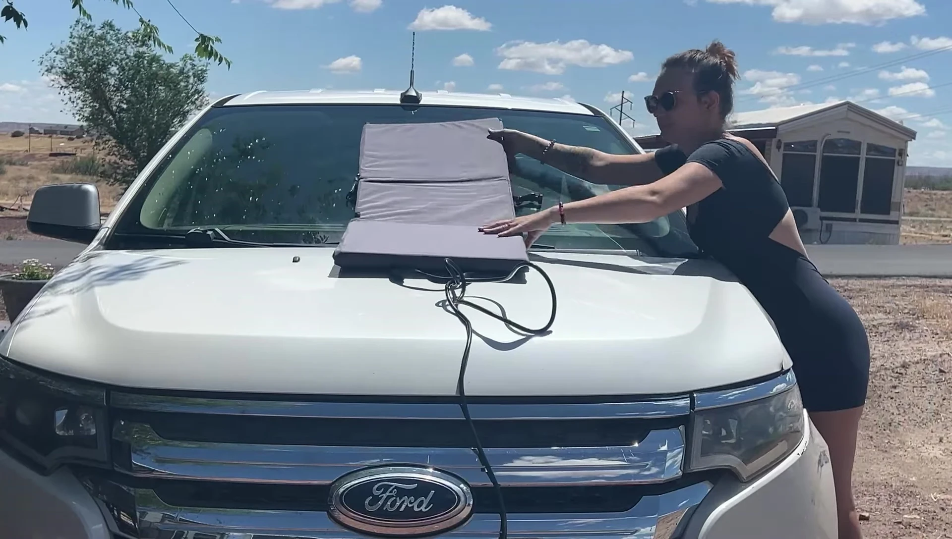 Amelia unfolding the Renogy solar blanket, demonstrating its easy setup process.