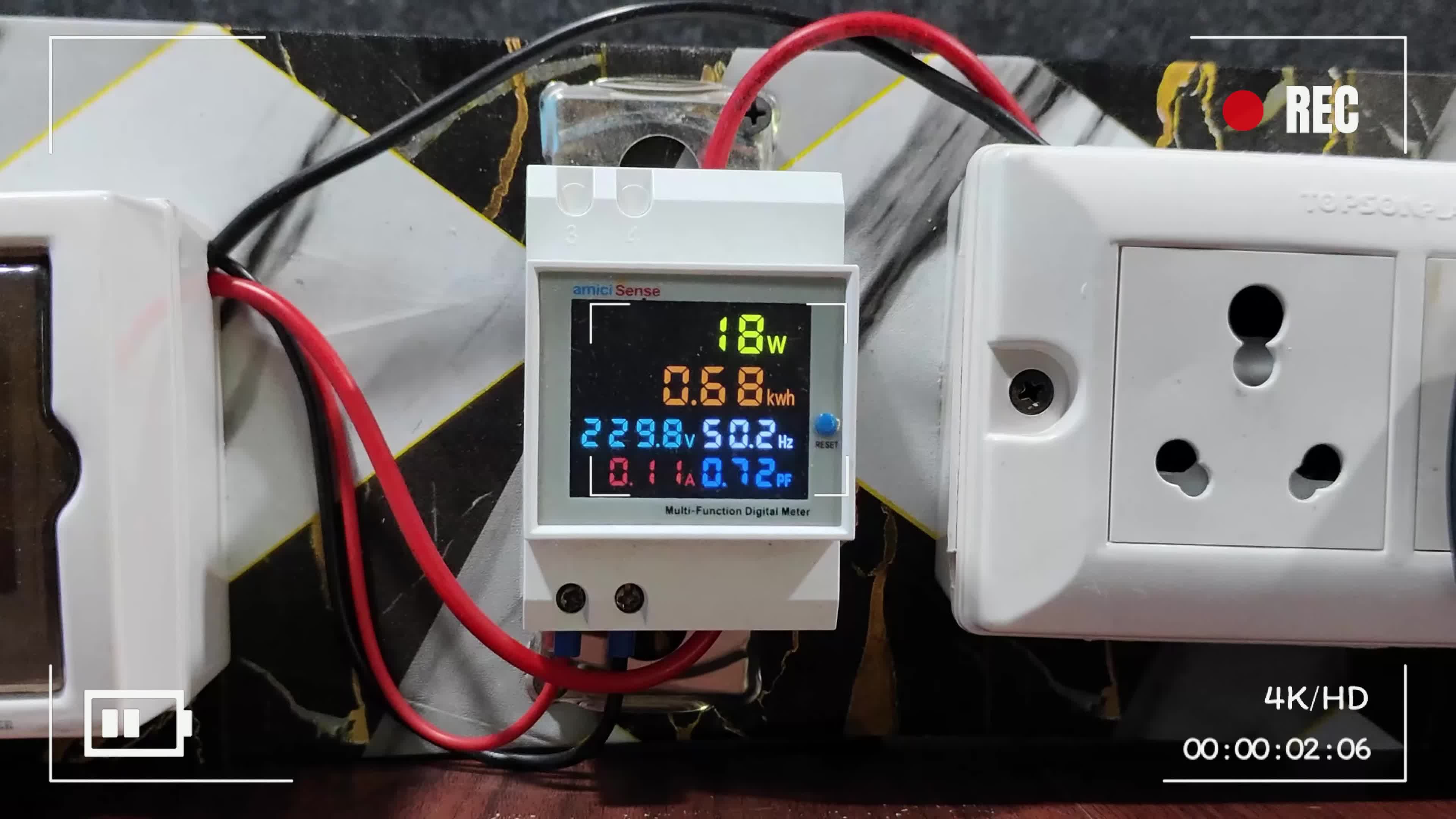Close-up of the AmiciSense energy meter's digital display showing clear readings.