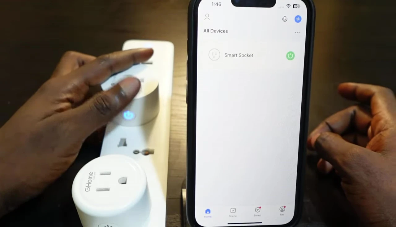 Close-up of the Gosund smart plug showing the power button being pressed.
