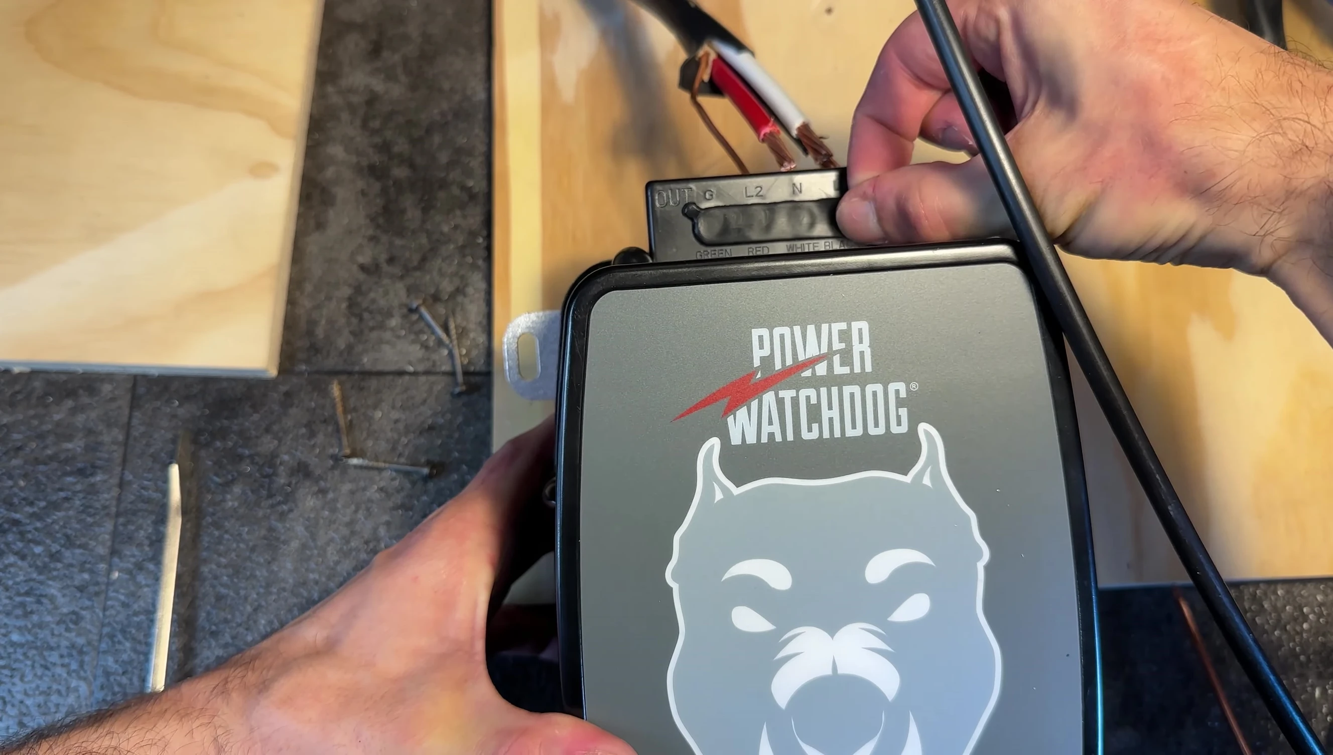 Connecting the wires to the surge protector terminals.