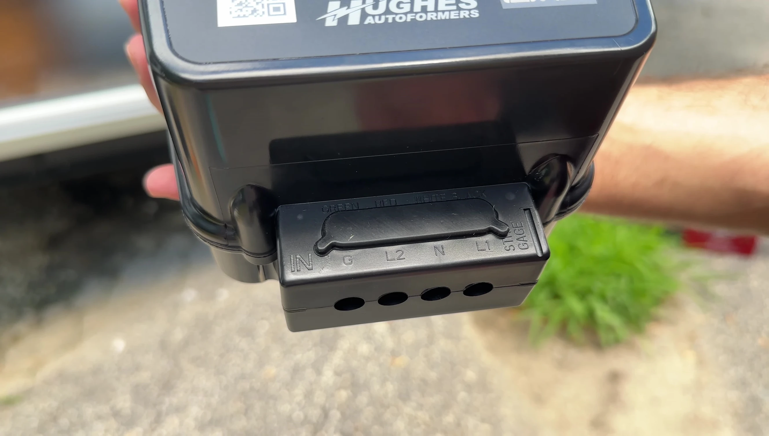 Detailed view of the surge protector unit, showing the ground terminal, hot lines (L1 and L2), and neutral terminals.