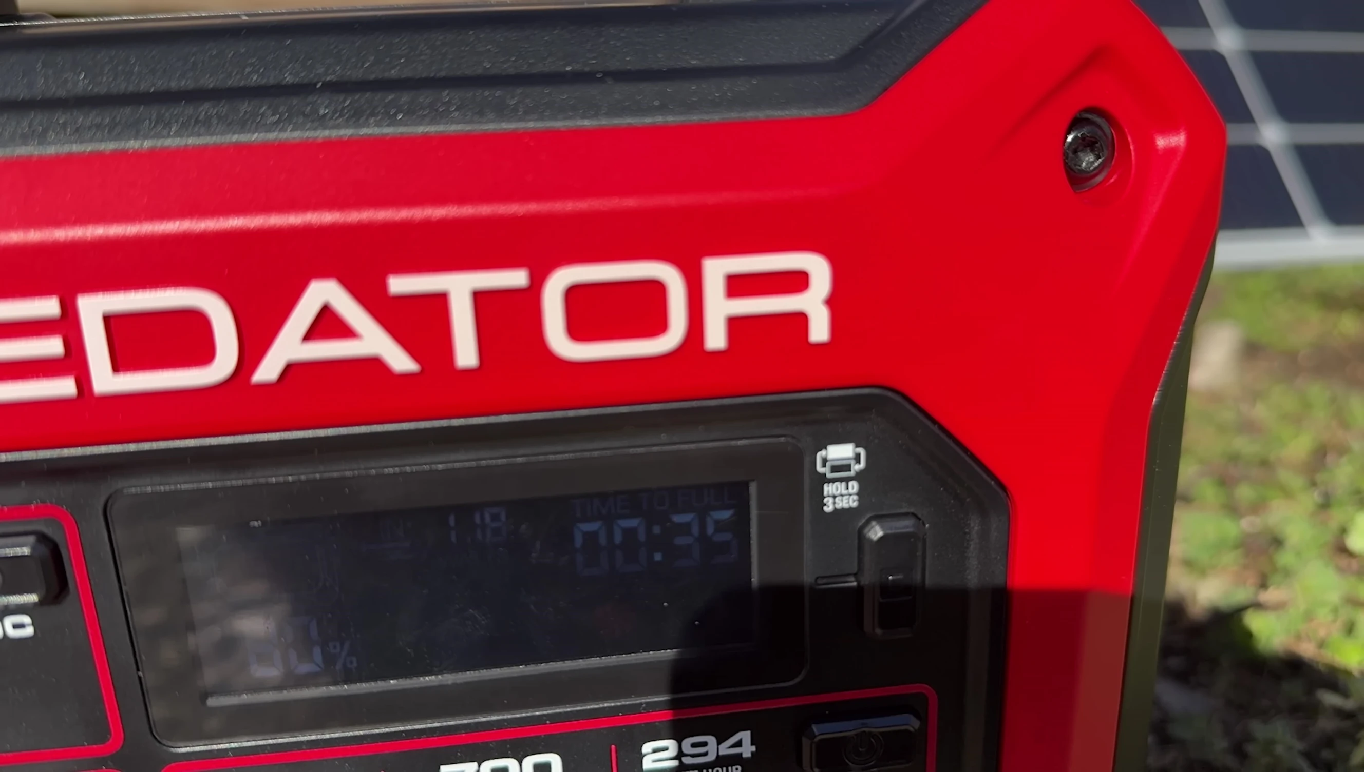 The solar panel charging the power station, with the screen showing charging wattage.