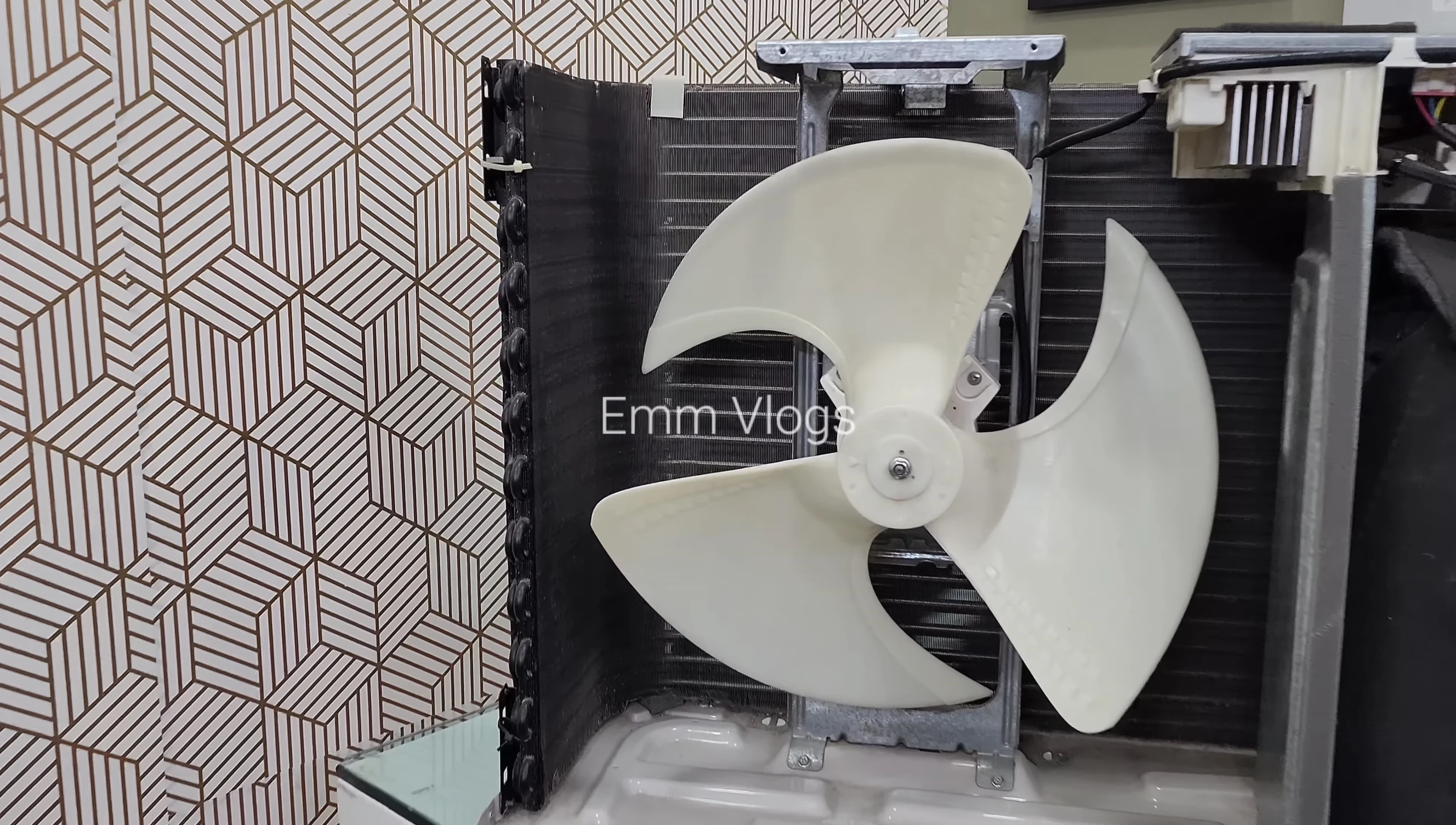 Internal view of LG AC, showcasing its two-row condenser coil and three-blade fan
