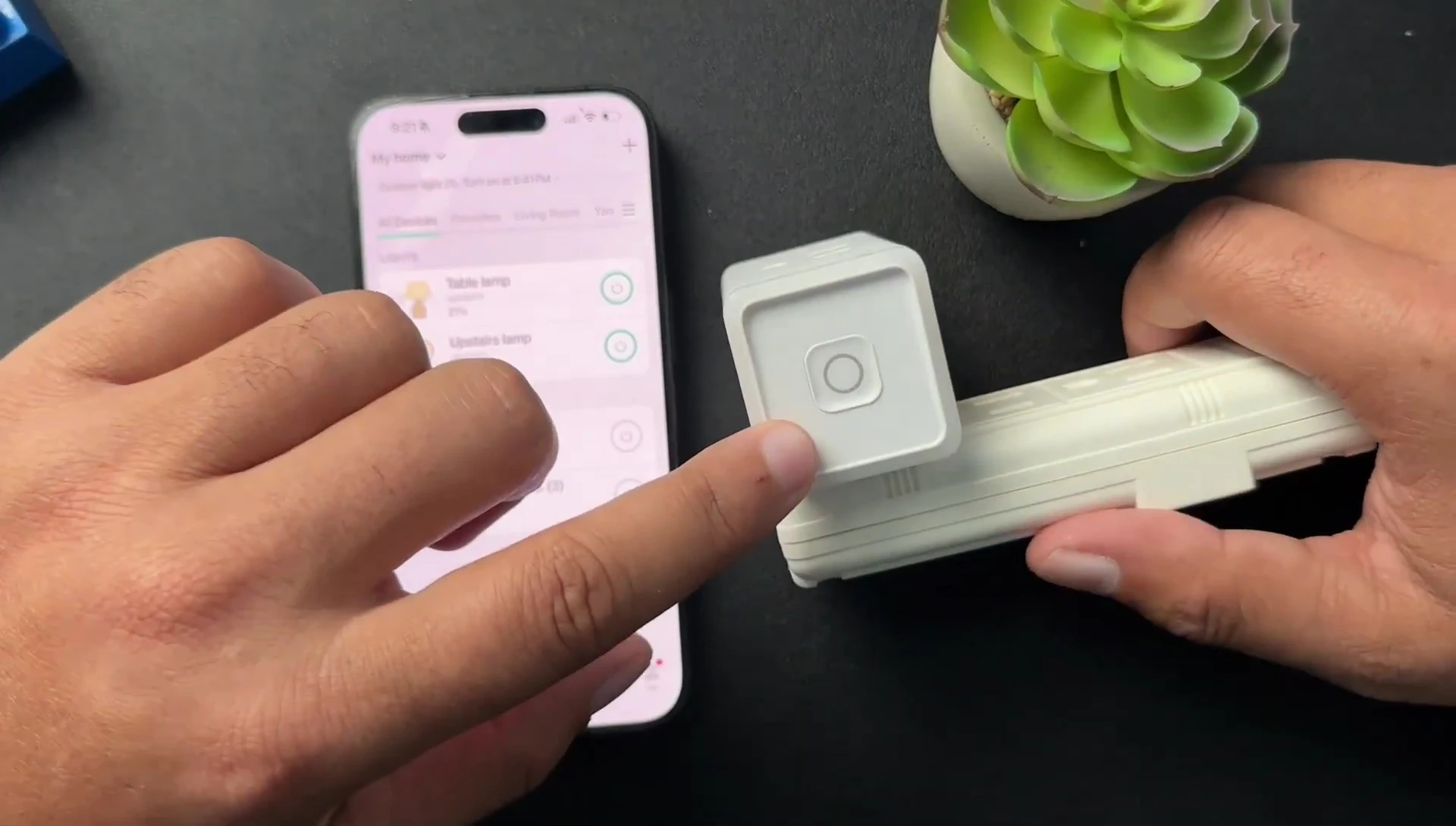 Hand pressing and holding the Kasa smart plug button