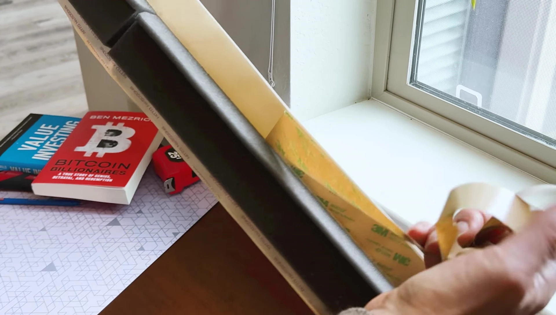 Peeling the liner from the adhesive strip.