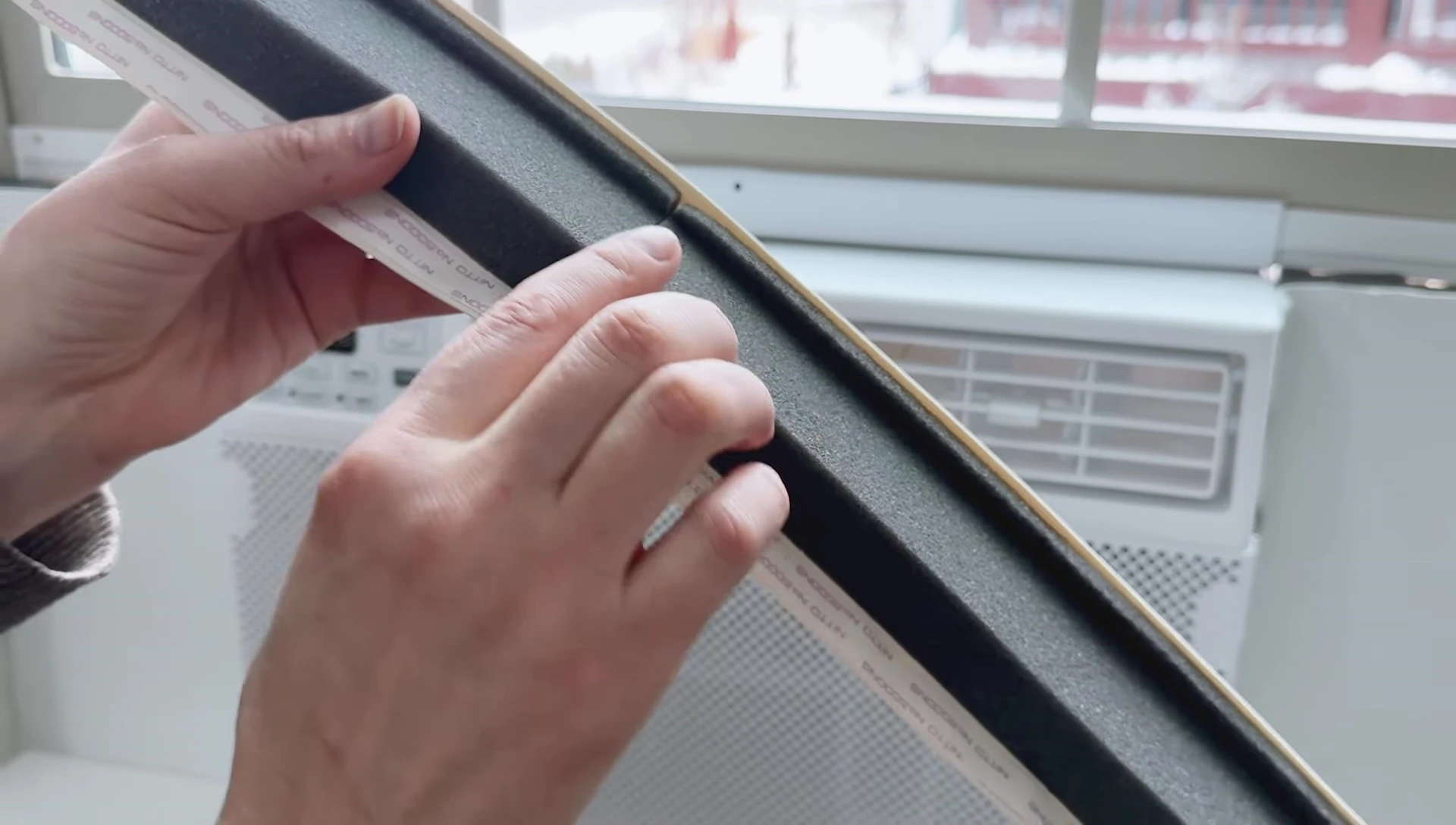 Positioning the top panel on the AC unit.